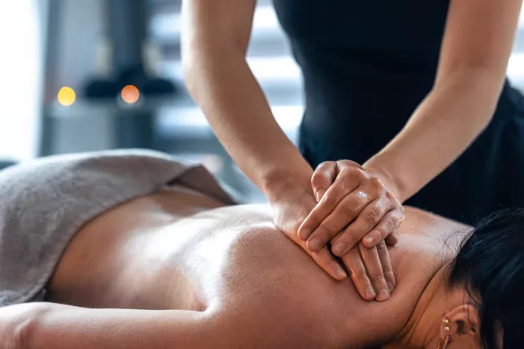 Handen van een masseuse tijdens een Thaise rugmassage